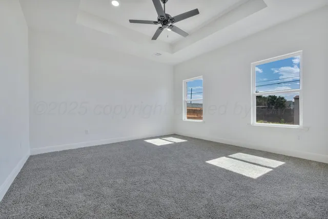 an empty room with windows and fan