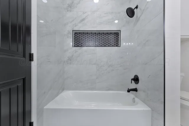 a bathroom with a tub and a shower