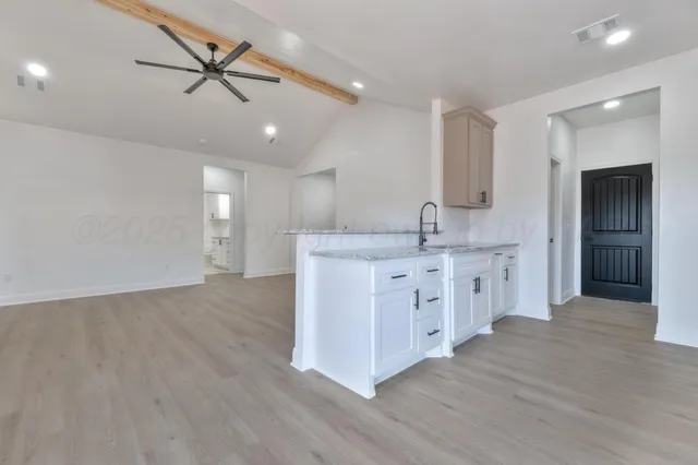 a kitchen with stainless steel appliances a sink cabinets and wooden floor