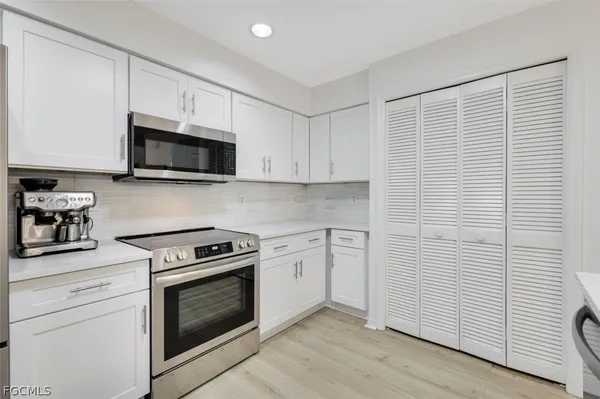 a kitchen with stainless steel appliances white cabinets and a stove top oven