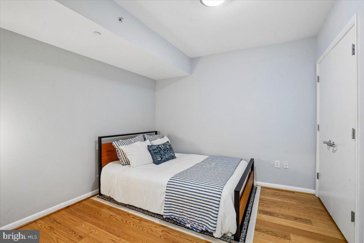 350 G Street Southwest, Unit N511 Washington, DC 20024 - Photo 21 of 27 a bedroom with a bed and wooden floor