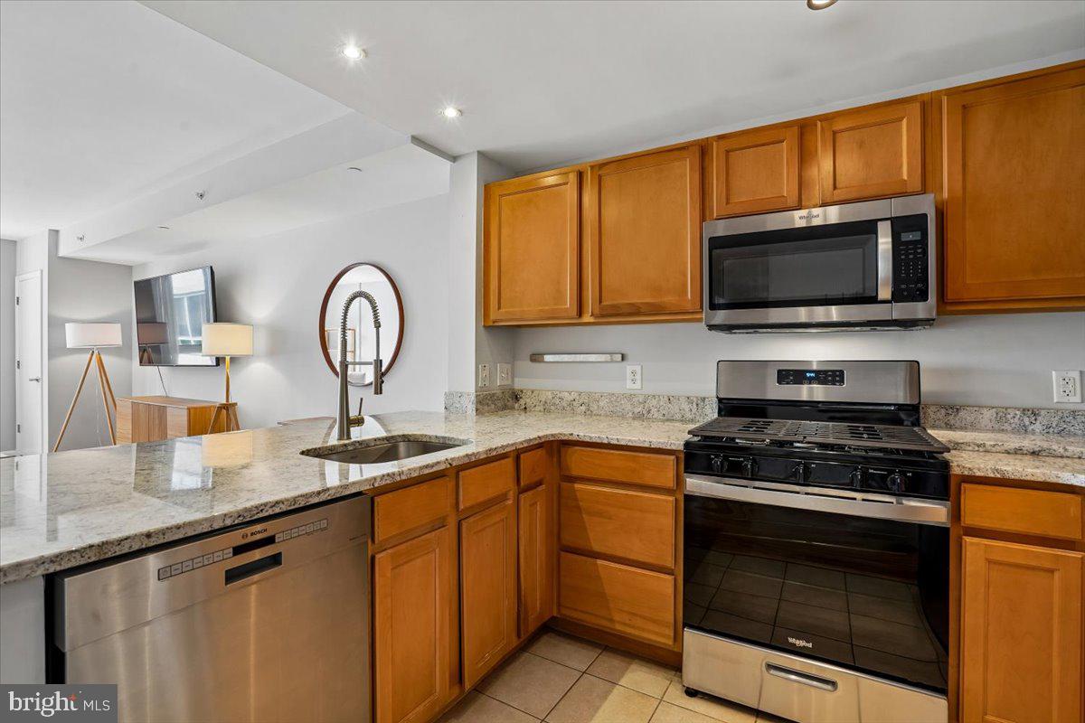 350 G Street Southwest, Unit N511 Washington, DC 20024 - Photo 4 of 27 a kitchen with stainless steel appliances granite countertop a stove a sink and a microwave