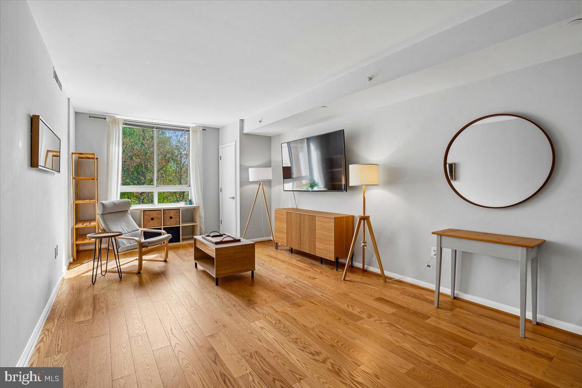 350 G Street Southwest, Unit N511 Washington, DC 20024 - Photo 8 of 27 a living room with furniture and a large window