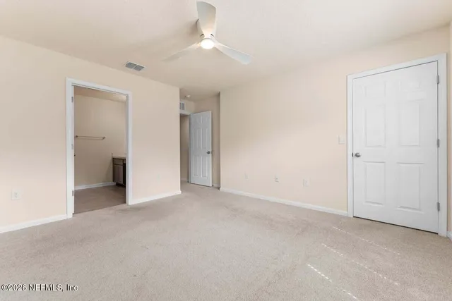 a view of an empty room with a ceiling fan