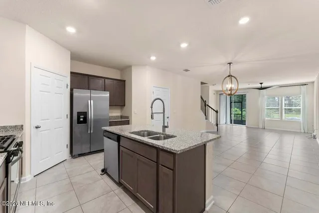 a kitchen with a sink a refrigerator and a stove top oven