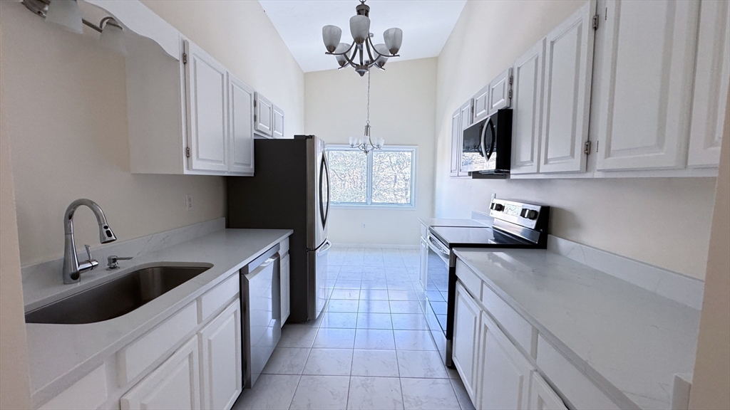 8 Ledgewood Way, Unit 20 Peabody, MA 01960 - Photo 37 of 37 a kitchen with stainless steel appliances granite countertop a sink a stove and refrigerator