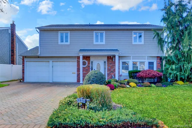 a front view of a house with a garden and plants