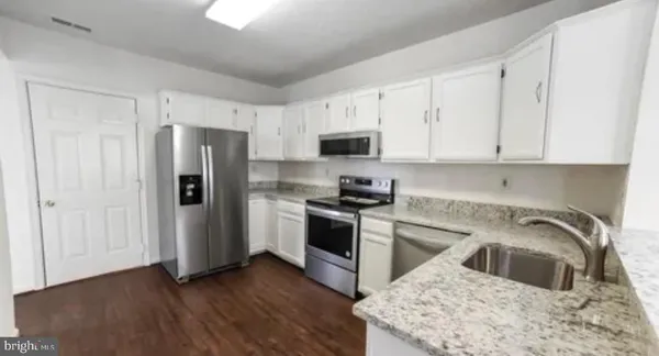 a kitchen with a refrigerator sink and cabinets