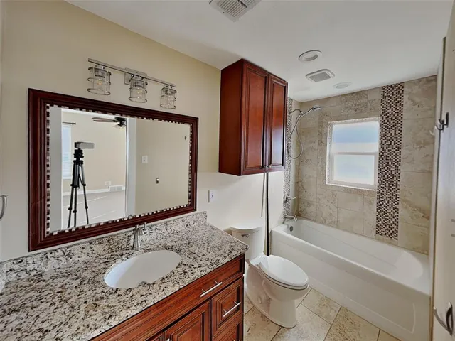 a bathroom with a granite countertop sink toilet and shower