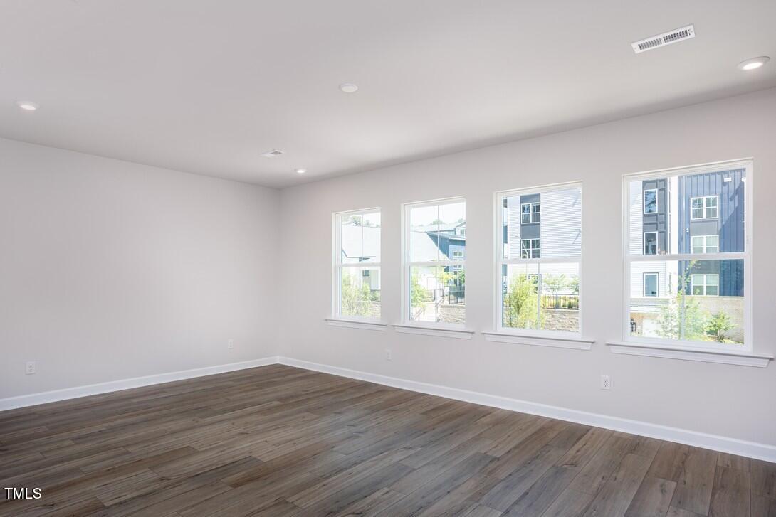 4703 Mint Leaf Lane Raleigh, NC 27612 - Photo 12 of 25 an empty room with wooden floor and windows