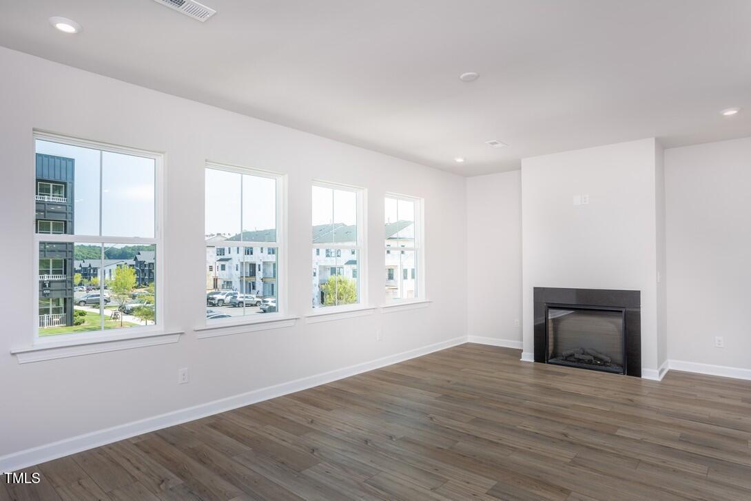 4703 Mint Leaf Lane Raleigh, NC 27612 - Photo 13 of 25 a view of an empty room with wooden floor and a window