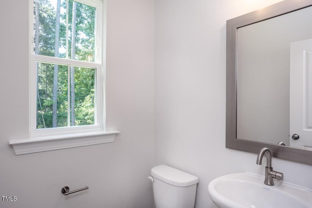 4703 Mint Leaf Lane Raleigh, NC 27612 - Photo 15 of 25 a bathroom with a sink a toilet and a window