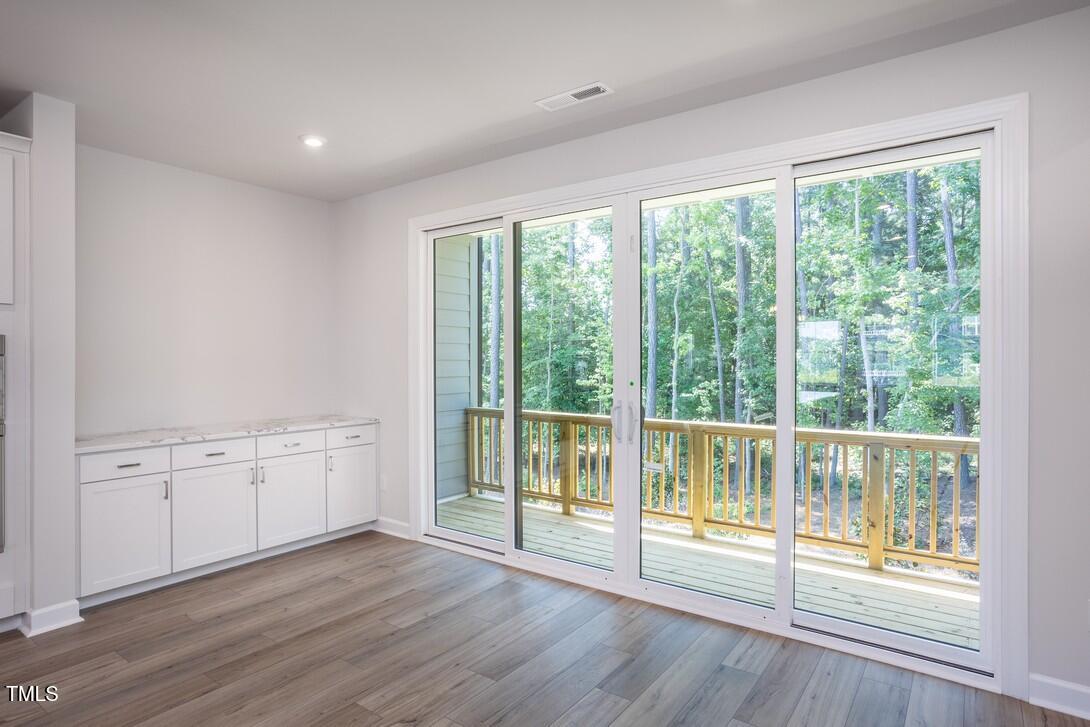 4703 Mint Leaf Lane Raleigh, NC 27612 - Photo 6 of 25 a view of an empty room with wooden floor and a window