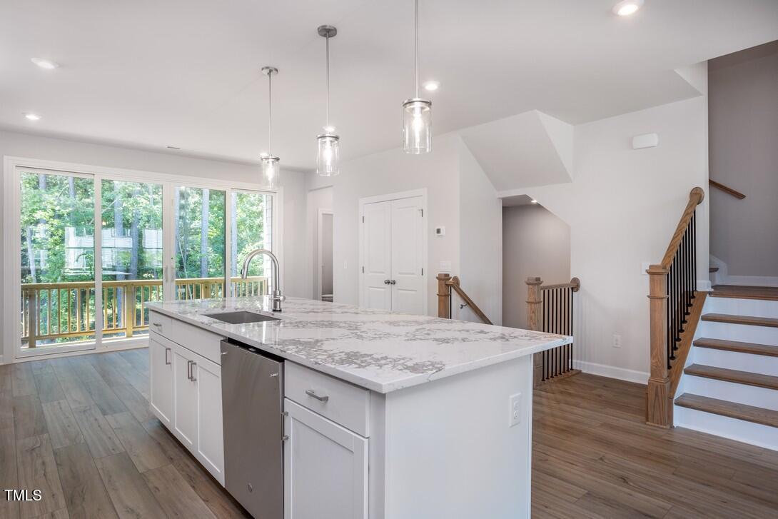 4703 Mint Leaf Lane Raleigh, NC 27612 - Photo 7 of 25 a kitchen with a stove a sink a wooden floor and a large window