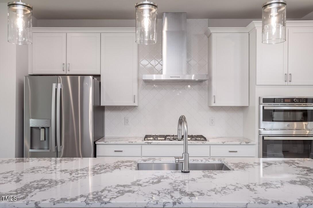 4703 Mint Leaf Lane Raleigh, NC 27612 - Photo 9 of 25 a kitchen with stainless steel appliances granite countertop a refrigerator sink and cabinets