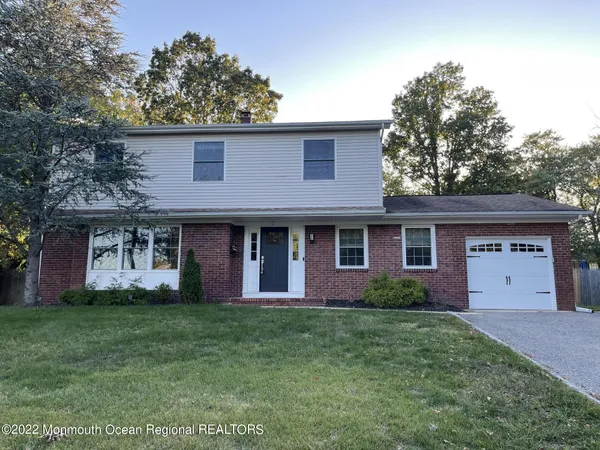 a front view of a house with a garden and plants