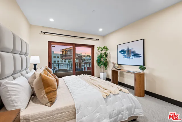 a bedroom with a bed and a large window