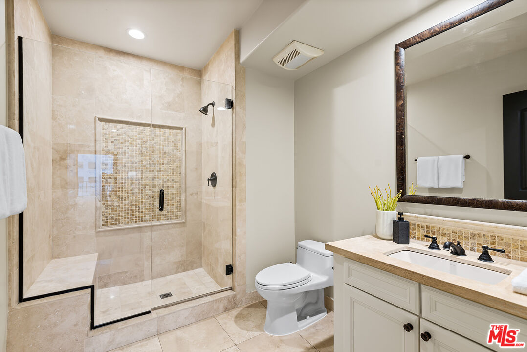 1215 Armacost Avenue, Unit 403 Los Angeles, CA 90025 - Photo 16 of 25 a bathroom with a granite countertop sink toilet and shower