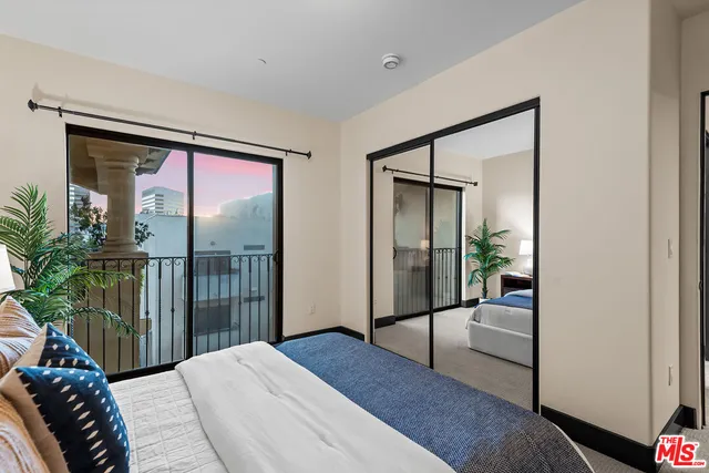 a bedroom with a bed and glass door