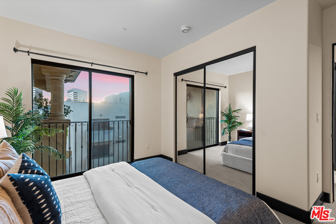 1215 Armacost Avenue, Unit 403 Los Angeles, CA 90025 - Photo 18 of 25 a bedroom with a bed and glass door
