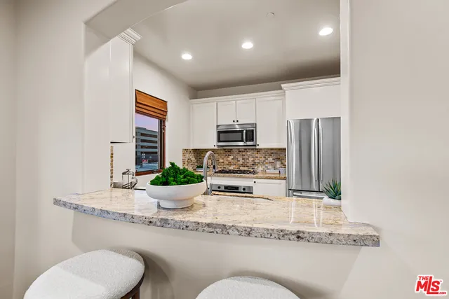 a kitchen with a refrigerator and a white cabinets