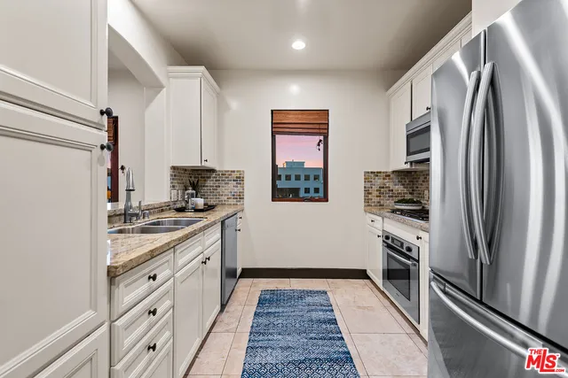 a kitchen with stainless steel appliances a refrigerator sink and stove