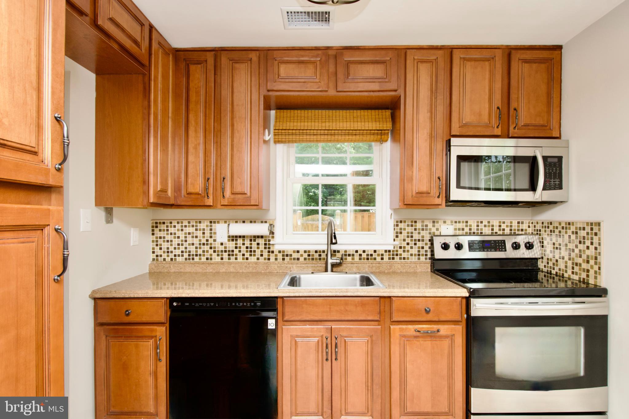 7726 Matisse Way Springfield, VA 22153 - Photo 14 of 34 a kitchen with stainless steel appliances a sink stove and cabinets