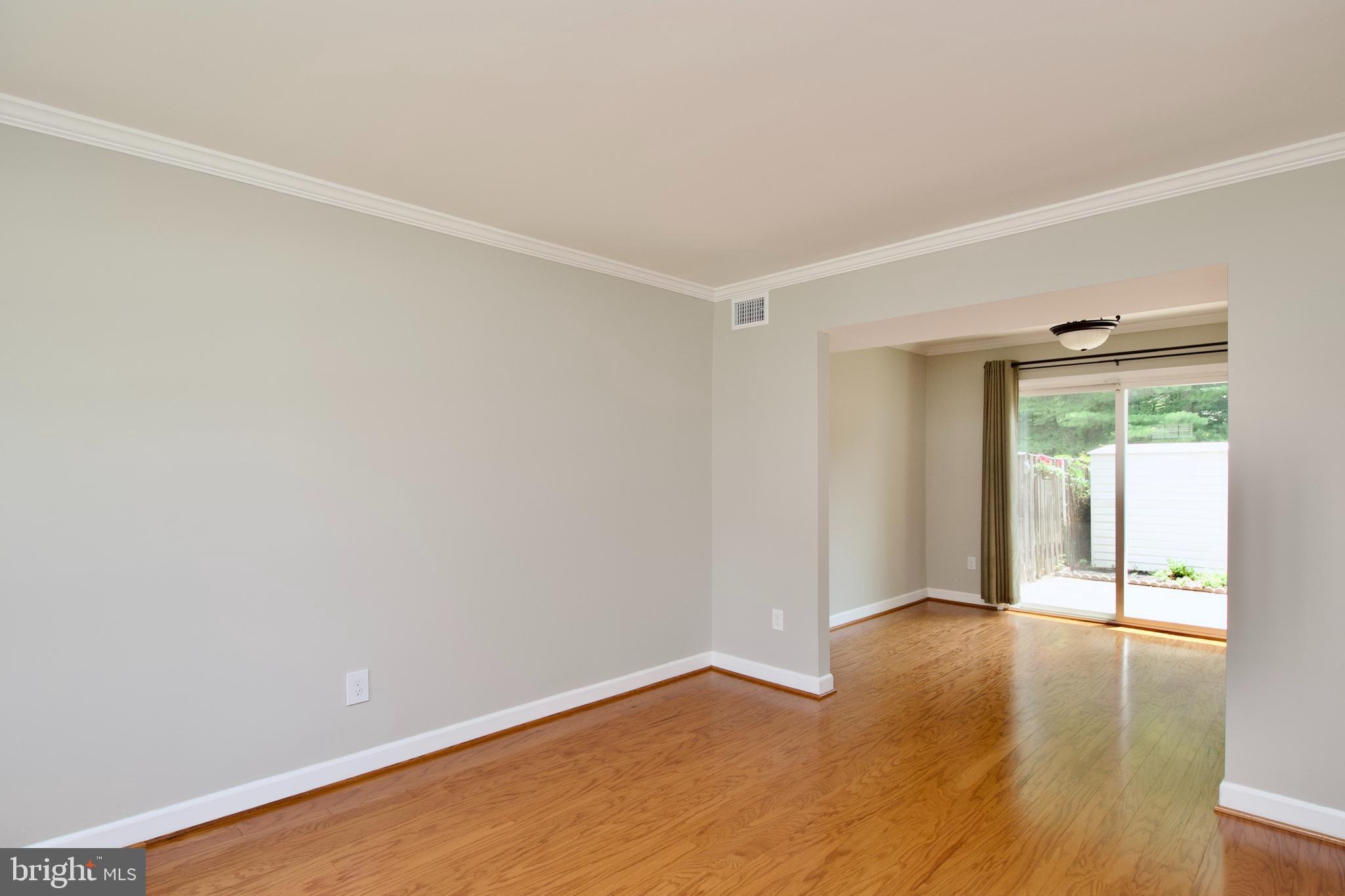 7726 Matisse Way Springfield, VA 22153 - Photo 7 of 34 a view of an empty room with wooden floor and a window