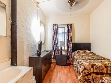 a bedroom with a bed and wooden floor