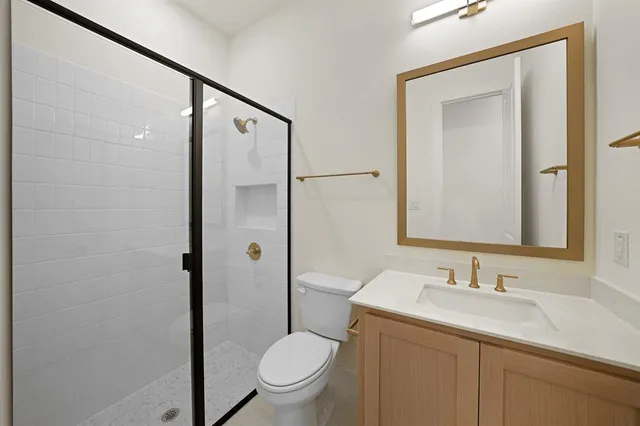 a bathroom with a granite countertop sink toilet and shower
