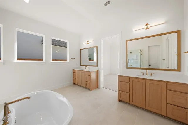 a bathroom with a tub sink and mirror
