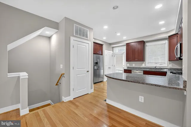 a large kitchen with stainless steel appliances granite countertop a refrigerator and a sink