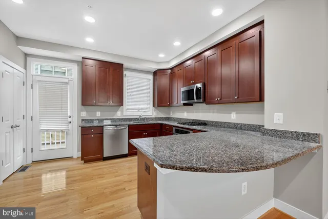 a kitchen with stainless steel appliances granite countertop a sink microwave and cabinets