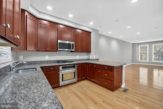 a kitchen with stainless steel appliances granite countertop wooden cabinets and a granite counter tops