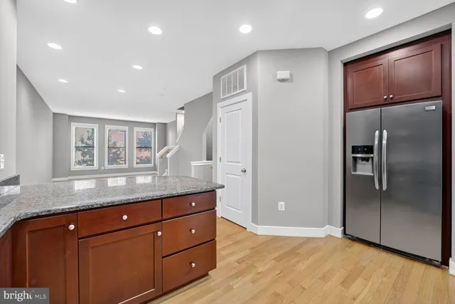 a kitchen with granite countertop stainless steel appliances and refrigerator