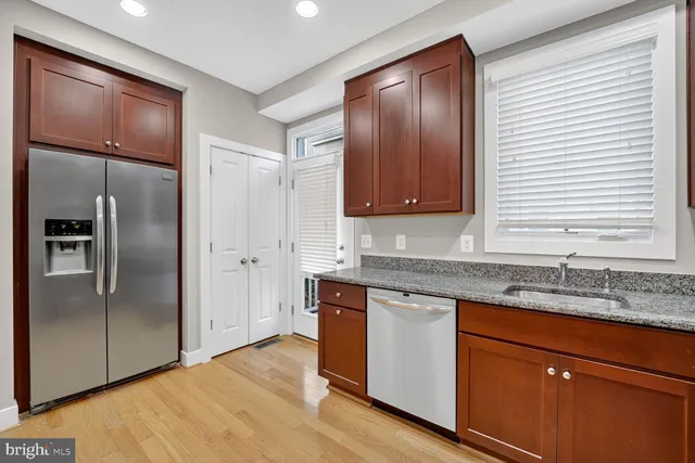 a kitchen with stainless steel appliances granite countertop a refrigerator and a sink