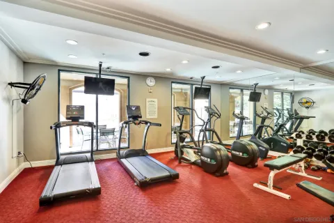 a room with gym equipment and large mirror