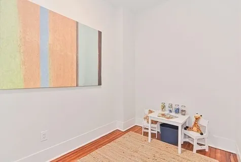 a view of a workspace with wooden floor and a window