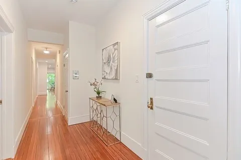 a view of a hallway with wooden floor and entryway