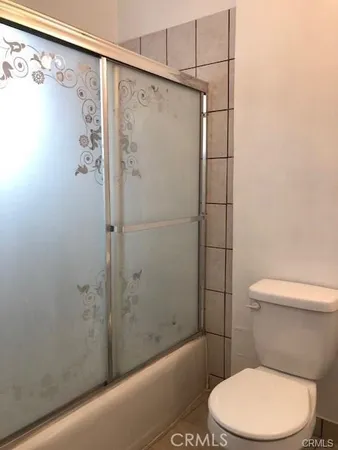 a white toilet sitting next to a bath tub and shower