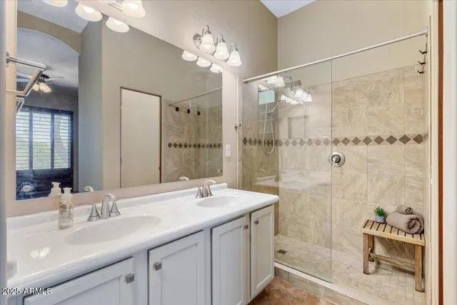an empty room with chandelier fan and windows