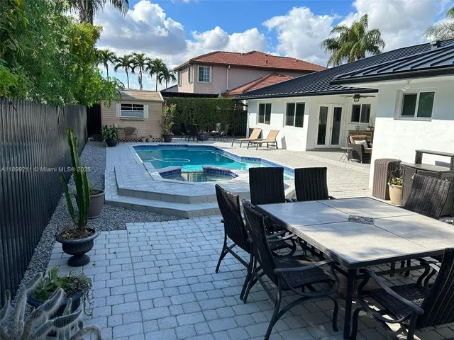 a view of a patio with table and chairs potted plants and large tree