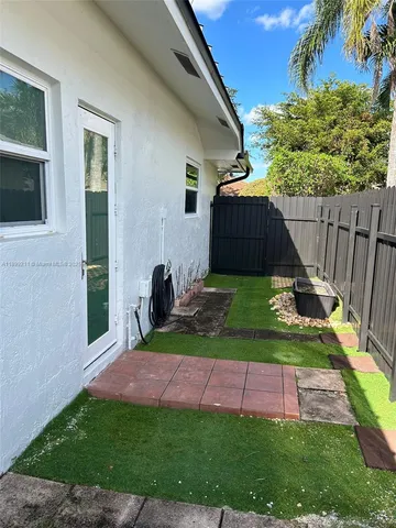 a view of backyard with potted plants and a wooden fence