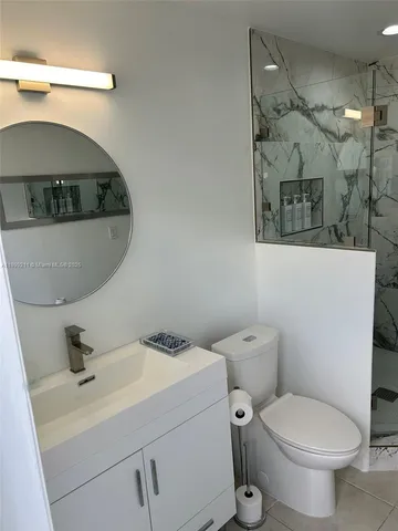a bathroom with a toilet sink and mirror
