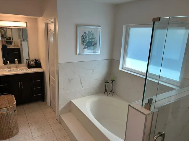 a bathroom with a bathtub sink and mirror