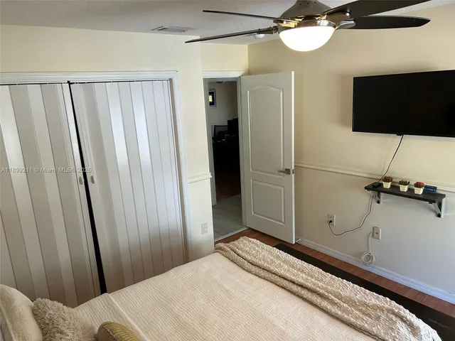 a bedroom with a bed and a flat tv screen on a dresser