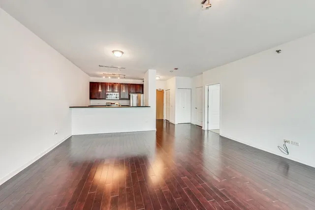 a view of a kitchen with wooden floor and a window
