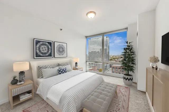 a bedroom with a large bed and a potted plant