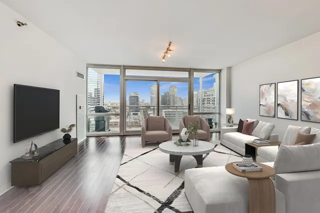 a living room with furniture large windows and wooden floor