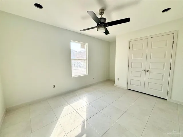 a view of a livingroom with a ceiling fan & windows